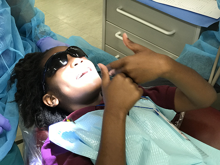 child in dental chair after screening at Give Kids a Smile Day